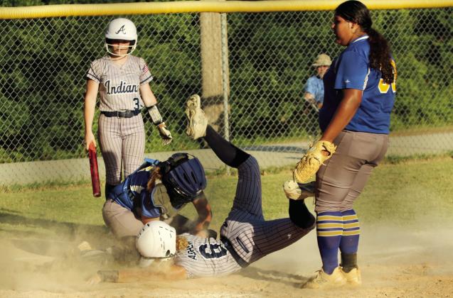 Asher junior Gracie Swinney dives into home only to be tagged out by the Moss catcher, as fellow junior Makaylee Harrell waits to finish batting, during the home game on Aug. 15. The Lady Indians played their first five fast pitch games of the season at home last week and won all but one. They beat Moss, 11-6.