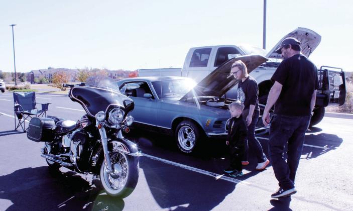 A family looks over the one motorcyle, a Harley Softail Deluxe owned by Thad Campbell of Bethel, at the First Annual Driven for Justice Car Show, held at Life. Church in Shawnee on Nov. 8. Natasha Dunagan, Countywide &amp;amp; Sun