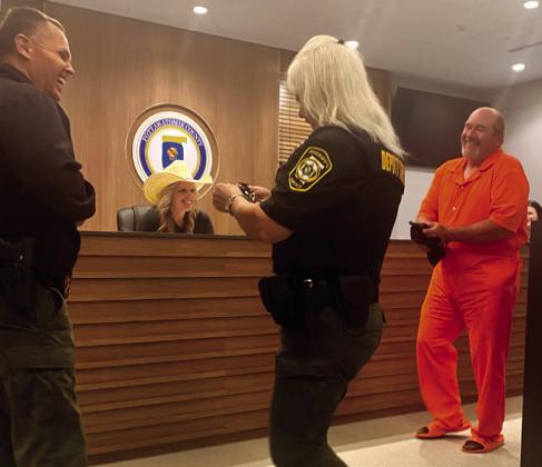 Commissioner Greg Rush revealed himself in his prisoner Halloween costume which resulted in a lot of giggles, belly laughs... and relief! Commissioner Abby Thompson (dressed as Miranda Lambert) is shown behind the desk as Deputy Sheriff Candie Griffin finds her key to unlock the cuffs. Sheriff Freeland Wood stands off to the side enjoying every minute. Julie Talton, Countywide &amp; Sun