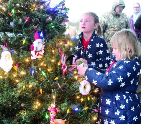 Cameron Boehler, 8, and Caylee Boehler, 5, hang their ornaments on the Bethel Christmas Tree during the tree lighting ceremony.