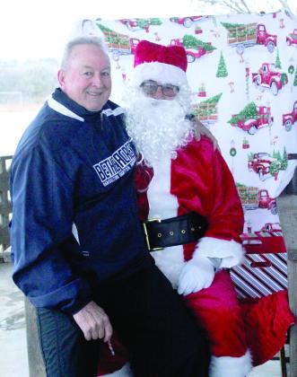 Bethel Acres Mayor Tony Carlile is the first person to sit on Santa's lap during the Bethel Community Christmas Tree Lighting Ceremony on Dec. 7 at the Community Center Pavilion.