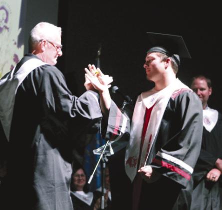 North Rock Creek High School Principal Chad Brooking shares a secret handshake with his son Holden Brooking after the graduate received his diploma at graduation on May 19. Countywide &amp;amp; Sun/ Natasha Dunagan