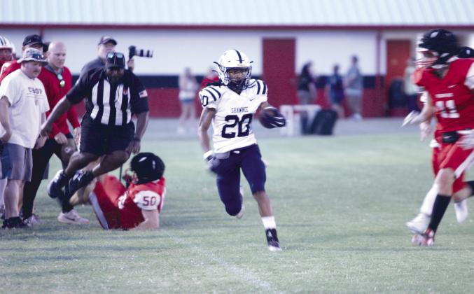 Shawnee senior Deetrick Beavers carries the ball along the sidelines.