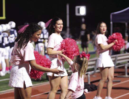A young girl delivers artwork to two Shawnee High School Pom Squad members, including Michale' Young, during the Oct. 10 Pink Out home game. Also shown are Madison Davis and Rayna Watson. Natasha Dunagan, Countywide &amp;amp; Sun