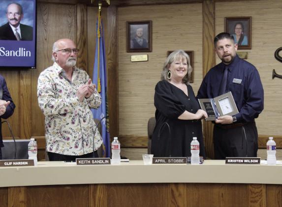 Shawnee Superintendent Dr. Aaron Espolt presents a clock plaque to retiring Board of Education Clerk April Stobbe, as fellow retiring board member Keith Sandlin and others applaud during the April 1 board meeting. This was the last meeting for Stobbe and Sandlin after more than 20 years each. Countywide &amp; Sun/Natasha Dunagan