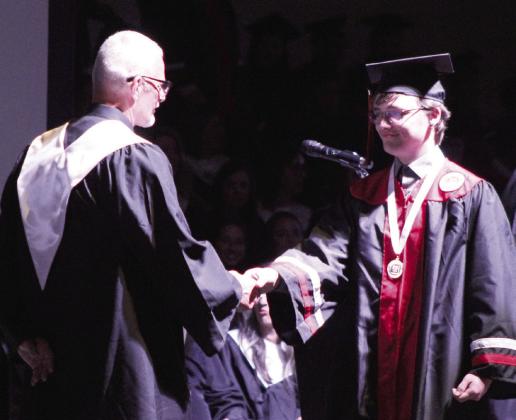 Lane Cowan shakes the hand of Principal Chad Brooking before receiving his diploma. Natasha Dunagan, Countywide &amp;amp; Sun