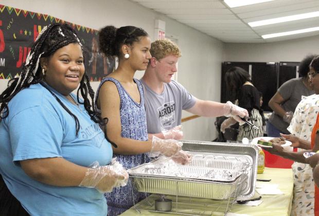 Shawnee High School sophomores Jailee Lewis, Khloe Tungate and Colton Herron serve dinner to the community during the celebration. Natasha Dunagan, Countywide &amp;amp; Sun