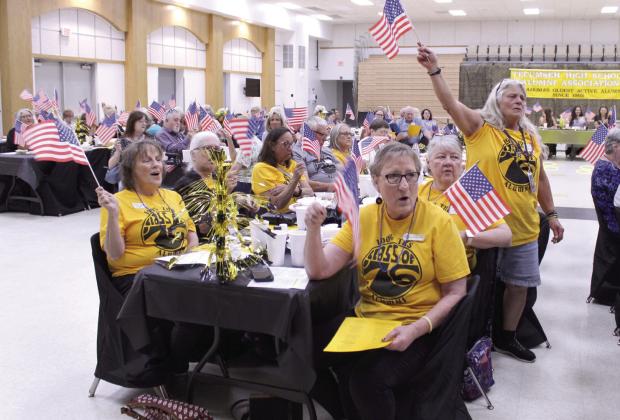 The Tecumseh High School Class of 1976 and other attendees wave flags provided by the Alumni Association and sing along to "God Bless America" at the 124th Annual Tecumseh Alumni Banquet, held at the WP Wood THS Alumni Center on May 30. Celebrating their 50th reunion, the Class of 1976 also received commemorative pins. In addition, 145 attendees sang along to "America the Beautiful," "Grand Old Flag" and "Yankee Doodle" in honor of the 250th anniversary of the United States.