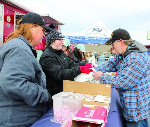 College student Maebrey Wallace gives Vietnam Veteran Frankie Knapp two free pork lunches at the Oklahoma Pork Council event, held at Gilbert Insurance and Tecumseh Tag on Dec. 16. They had 300 lunches to give away, and 200 were gone in the first hour. Tecumseh was one of seven towns chosen across the state for this event. Also shown, from left, are Tammy Kline, Wallace, Blakelee Pugh, and Baylee Weeks. Natasha Dunagan, Countywide &amp; Sun