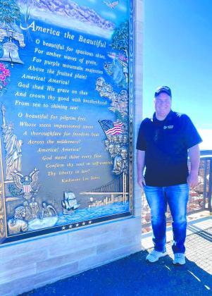 Tecumseh Band Director John Outon poses by the “America the Beautiful” monument at Pike’s Peak in Colorado recently. Outon took his band students on the trip, and they played a concert at the America The Beautiful Park. Photo provided.