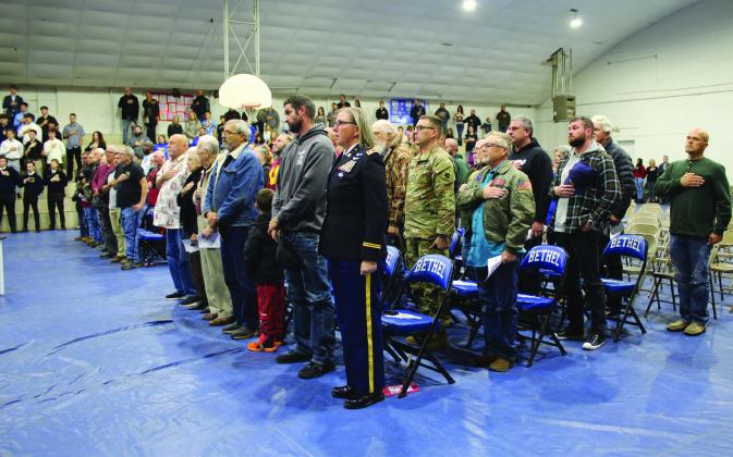 Veterans stand at attention or salute the flag during the national anthem at Bethel High School's Veterans Day Program on Nov. 11 in the Old Gym. Countywide &amp; Sun/Natasha Dunagan
