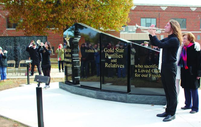 Shawnee High School students Sophia Canaga and Riley Cooper echo each other in "Taps" on either side of the new Gold Star Families Memorial Monument on Nov. 11. Gold Star Family members Donna Warren (hidden) and Nancy Ford, far right, helped to unveil the monument. Countywide &amp; Sun/Natasha Dunagan