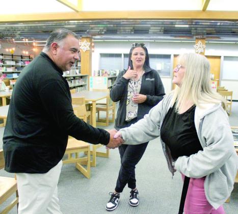 New Tecumseh High School Head Football Coach Randon Lowe shakes hands with English teacher Valerie Stokes, as parent Tedda Hogan looks on, during the meet-and-greet held in the THS library on April 21. Mike Montano, the new Defensive Coordinator, was also at the event. Natasha Dunagan, Countywide &amp;amp; Sun