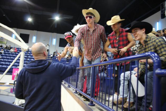 "Cowboys" in the Shawnee Student Section shake hands with Coach Eric Litherland