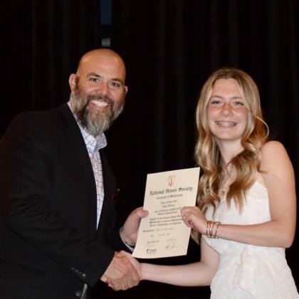 SHS Principal Matt Johnson presents an NHS certificate to junior Anna Jordan.