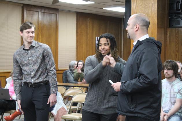 Coach Litherland fist bumps Jaylon Orange.