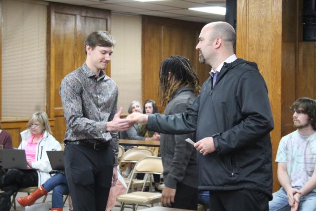 Coach Litherland shakes hands with Tanner Morris.