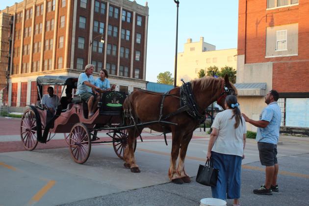 Stanton Pace waits for a lady to pet "Spirit" the Belgian draft horse before driving the Spirit Coach around downtown Shawnee. Free carriage rides were offered during Blues on Broadway on June 18. Countywide &amp; Sun/Natasha Dunagan