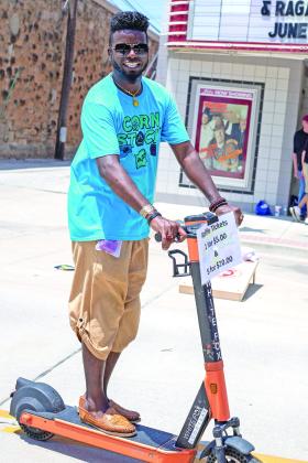 Jamelle Payne (MC for the event) rides his scooter up and down Main Street selling raffle tickets and hyping up players.  Countywide &amp; Sun/Loren Knight