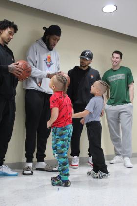 Potawatomi Fire players, from left, Deon Lyle, Anthony Allen, Tevin Foster, and Calvin Giles, Jr., sign basketballs for twins Kamden and Kash Bates at the Shawnee Early Childhood Center on April 27. During their visit, they also worked on dribbling with six students selected from the audience, advised them to listen to their teachers and parents, posed for pictures with each class, and handed out tickets to a Fire game. Countywide &amp; Sun/Natasha Dunagan