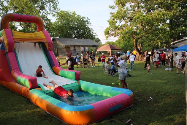 Neighborhood children enjoy the inflatable water slide.