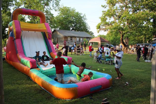 Neighborhood children enjoy the inflatable water slide.