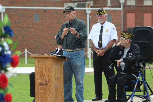 Veterans Memorial Committee member Al Brase speaks as VFW Post 1317 Commander-elect Patrick "Gunny" Koch and the VFW Chaplain looks on.