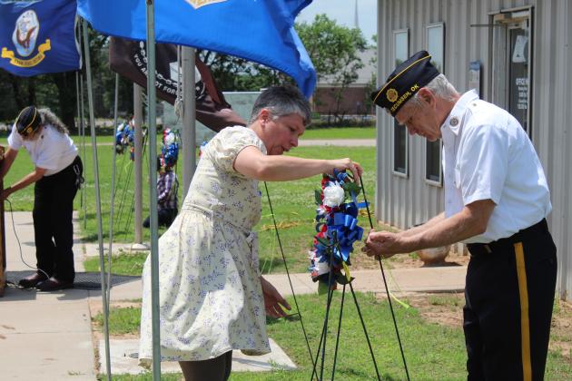 Misty Stone &amp; Stuart Rose place a wreath.