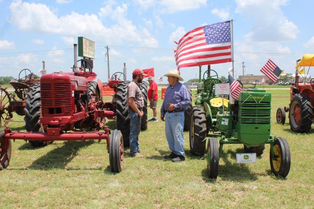 Shawnee Tractor and Engine Club member Dylan Smith, left, and Ellis Rooks, of McLoud, talk between the Farmall and John Deere tractors during the 23rd Annual Farming Heritage Festival on June 18 at Shawnee Feed Center. Rooks said he didn't bring a tractor to the festival, but he has several on his farm. He tries to attend the event every year. This year, there were farming demonstrations, a classic tractor parade, and tractor pulls. Kids could also pump water, shell corn, or jump in the bounce house.