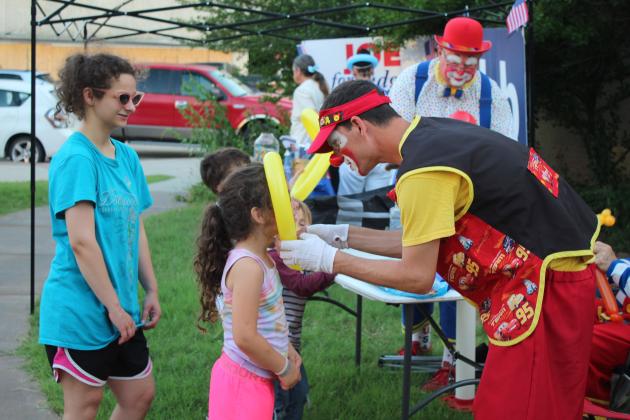 "Pockets," Jerry Biffel with the India Shriners, measures Patti Kerbs, 5, for a crown, as her sister Kerriagan Kerbs, 15, looks on at Blues on Broadway.