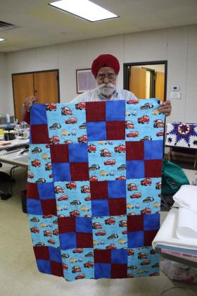 Bhupinder S. Obrai shows the baby quilt top he completed at Quilt Camp.