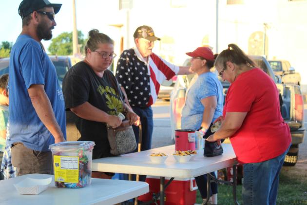 Carla Brandow, right, vice president of the Wanette Flag Day organization, sells nachos at the Wanette Independence Day event.