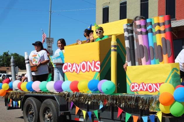 Two "crayons" wave from the Kickapoo Headstart float in the McLoud Blackberry Festival parade on July 9. Kickapoo Headstart won the parade contest for the second year. Countywide &amp; Sun/Natasha Dunagan