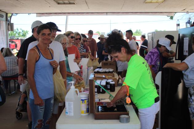 McLoud Chamber of Commerce volunteer Brenda Hill makes change for a customer, as many others wait in line, at the Blackberry Festival. The Chamber made $22,000, before expenses, selling fresh blackberries, blackberry jam and T-shirts. Countywide &amp; Sun/Natasha Dunagan