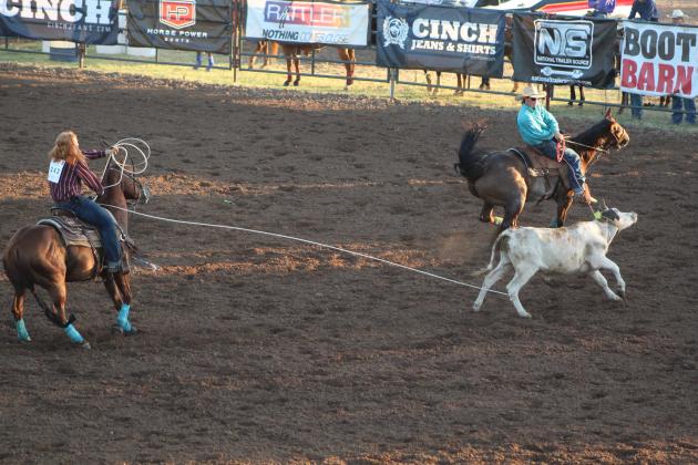 Braxton Ogle, of McLoud, right, holds the calf's head as Cotton Walters, of Paden, ropes its back legs during the IFYR Team Roping event on July 11. Countywide &amp; Sun/Natasha Dunagan