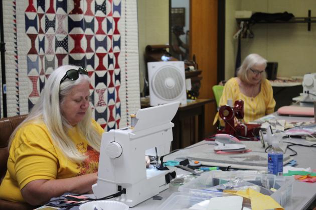 Guild President Marilyn Johnson, left, of Tecumseh, and Dee Cobb work on quilting project at Quilt Camp on June 25.