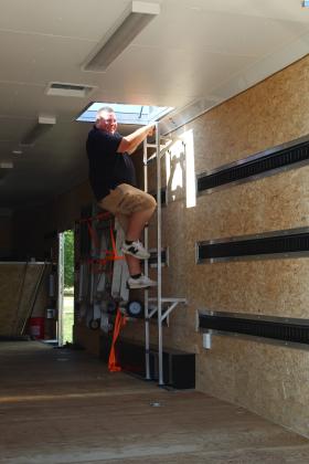 Tecumseh Band Director John Outon climbs down from the roof of the new band trailer.