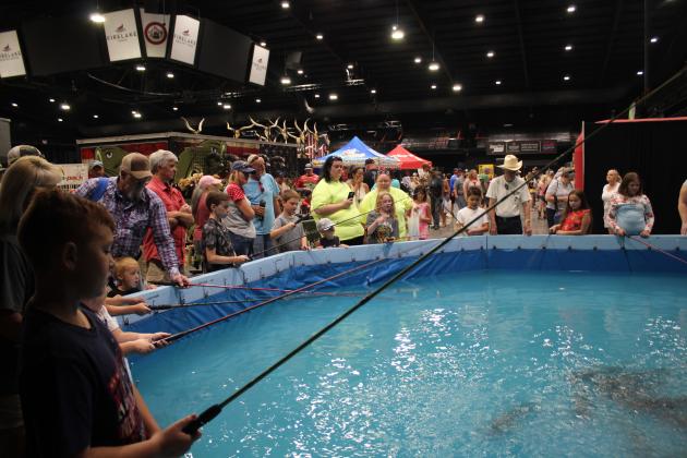 Children and parents surround the Army Bass Anglers Catfishing Tank during the Outdoor Nation Expo on Aug. 13 at FireLake Arena. Brent Hill, of the Army Bass Anglers, said they had over 100 participants on Aug. 12 and were at 20 by mid-morning on Aug. 13. The ONE had at least 18,000 visitors this year. Countywide &amp; Sun/Natasha Dunagan