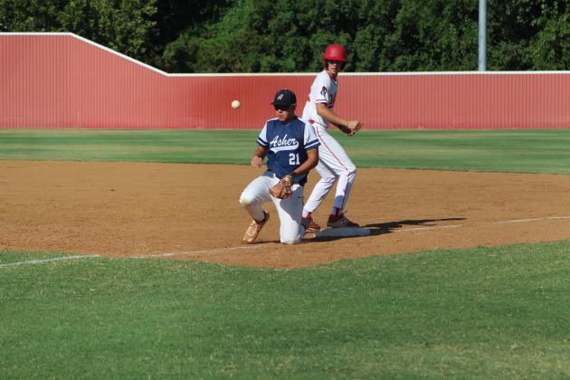 Safe at first base, Dale’s Jake Green watches as Asher first baseman Brogan Culwell drops to block and catch the throw to first base.