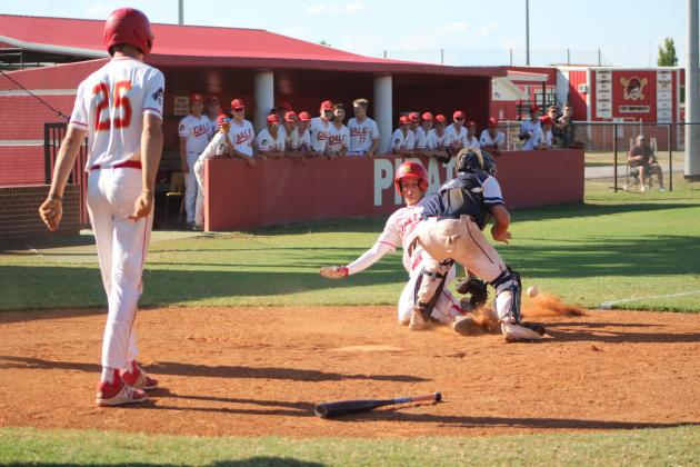 Dale’s Jake Green slides toward home base, as Asher’s catcher, Brian Ballard, tries to tag him and Dason Sheppard (#25) watches, during the Dale home game on Aug. 18. Sheppard had just stolen home, as well. Dale won 11-3.