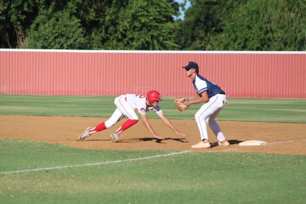 Dale's Kash Van Brunt dives back to first base after trying to steal second, as Asher first-baseman Brogan Culwell watches for the throw during the Dale home game on Aug. 18. Countywide &amp; Sun/Natasha Dunagan