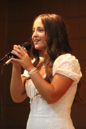 Miss Frontier Days contestant Taylor Gage leads the audience in singing "Oklahoma" during the Frontier Days Pageant on Sept. 11, held at the Tecumseh City Hall Auditorium. Countywide &amp; Sun/Natasha Dunagan