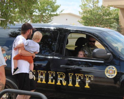 Chesney Rogers, 4, watches her father Jacob Rogers and brother Bowen Rogers, 1, all of Norman, as they get into the back seat of a Pottawatomie County Sheriff's SUV during Cops n' Kids on Aug. 27 at the Heart of Oklahoma Expo Center. Countywide &amp; Sun/Natasha Dunagan