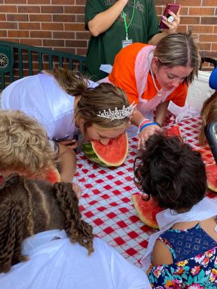 Miss Frontier Days, Sadie Boatman, and others eat watermelon hands-free during the Frontier Days Watermelon Eating Contest on Sept. 17. Photo provided.