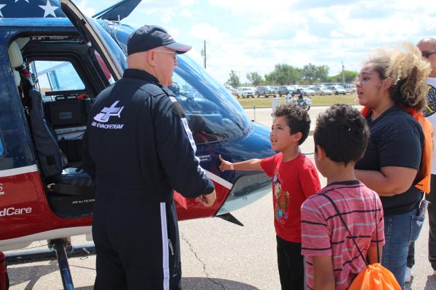 Ziah Ponkilla-Johnson, 9, and his mother, Keyana Johnson, ask questions of Air Evac Lifeteam Base Line Pilot Gordon Vandivort, as Ziah's brother, Zayden, 7, listens during Cops n' Kids on Aug. 27. Countywide &amp; Sun/Natasha Dunagan