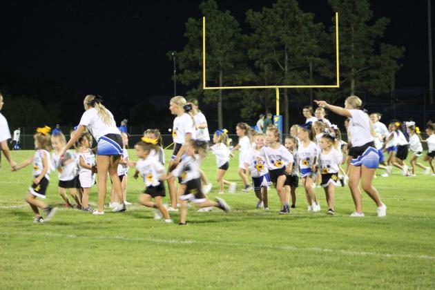 The Little Miss Wild Kitty cheerleaders are led onto the field by Bethel High School cheerleaders.