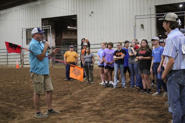 Burton Harmon, of the Oklahoma Farm Bureau in OKC, speaks to FFA and 4-H members about safely working with cattle at the 13th Annual Farmhand Olympics on Sept. 7 at the Heart of Oklahoma Expo Center. He advised using sticks with flags to direct cattle. Countywide &amp; Sun/Natasha Dunagan