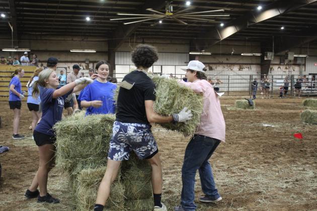 The North Rock Creek FFA Team #2 works together to stack hale bales during the team relay races at the 13th Annual Farmhand Olympics on Sept. 7. Shown, from left, are Berklee Gossen, Addyson Troxel, Alex Andrews and Stephen Wickerd.  Members of the teams also had to sack race and roll a tractor tire around hay bales, all while wearing a cow bell. About 52 FFA and 4-H members from around the county participated this year, and Macomb FFA Team #2 won the relay with 615 points. Countywide &amp; Sun/Natasha Dunagan