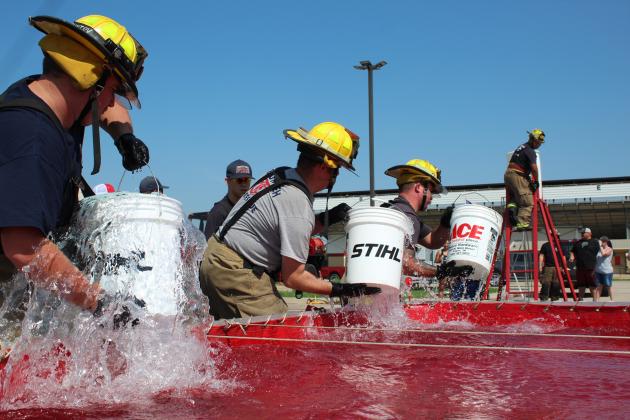 Tecumseh firefighters race the clock in the Bucket Brigade event of the Firefighter Olympics at the Pottawatomie County Free Fair on Sept. 10. Shown, from left, are Connor Franetovich, Zac Stephenson, Eddie Kidney, and on the ladder, Caden Shirey. Watching from the background is Preston Hurst. The event is organized by rural fire coordinator and retired Shawnee firefighter Paul Simpson, and has been since 1996. Countywide &amp; Sun/Natasha Dunagan