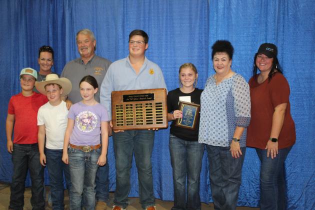 The 26th Annual Ann "Sis" Gilbert Memorial Award is presented to Berklee Gossen, of North Rock Creek FFA, third from right, as Cooper Kline holds the plaque with past winners during the Pottawatomie County Free Fair Awards on Sept. 10. Suzanne Gilbert said the award's namesake, her mother-in-law, kept the Fair's books and volunteered in other ways, as well. About Gossen, Gilbert said she shows sheep and goats, judges, has FFA exhibits, and she never sees her without a smile and an offer to help.